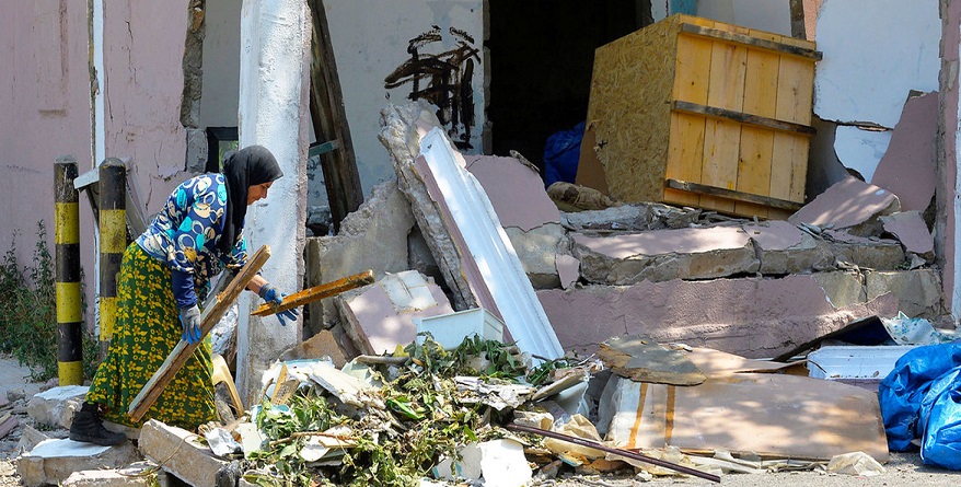 A woman in Beirut searches through the rubble that was once her home after a blast on 4 August pummeled her home.